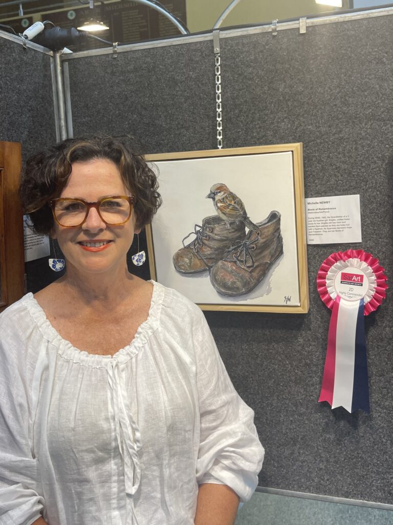 Artist standing beside her winning artwork