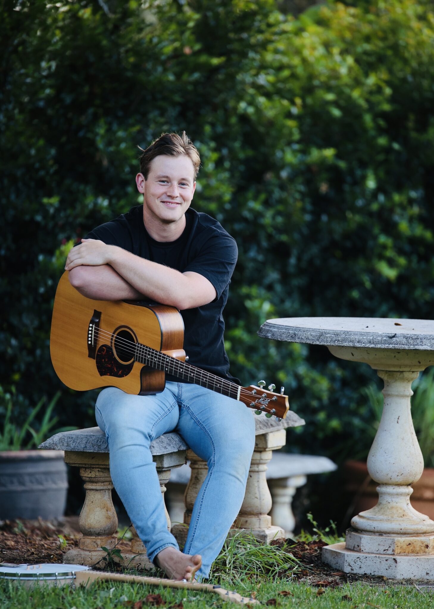 Will Outidge sitting with his guitar