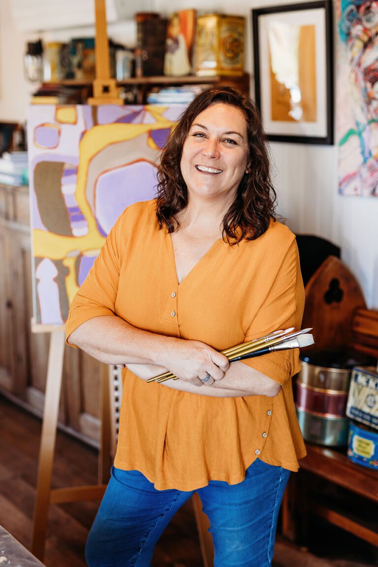 Smiling artist Standing with brushes